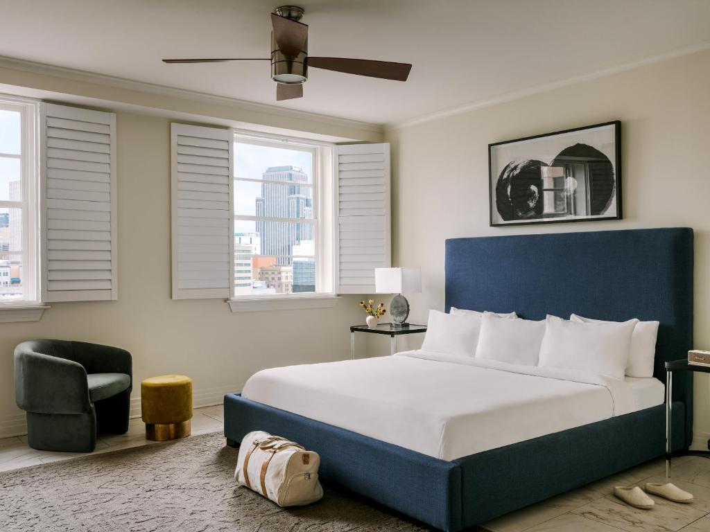 1 dormitorio con 1 cama, 1 silla y ventanas en Sonder at 1500 Canal en Nueva Orleans