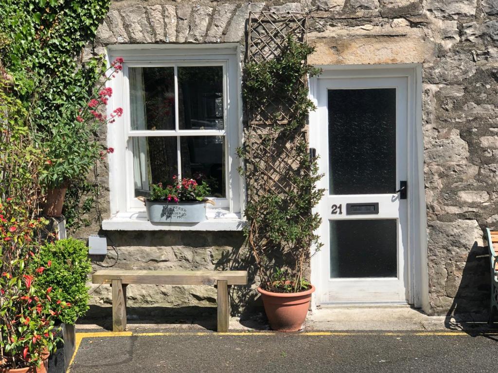 a stone house with a bench and a window at 21 Entry Lane in Kendal