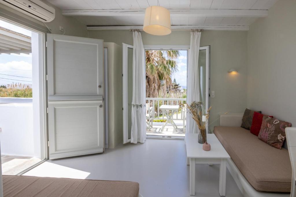 een woonkamer met een bank en een open deur bij Soulmate's Suites Tinos in Kionia