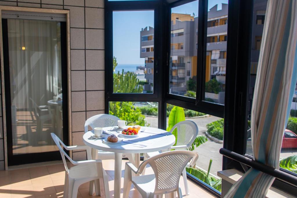 un tavolo e sedie su un balcone con vista sulla città di Casa Ritella - ApulianStay Group a Monopoli