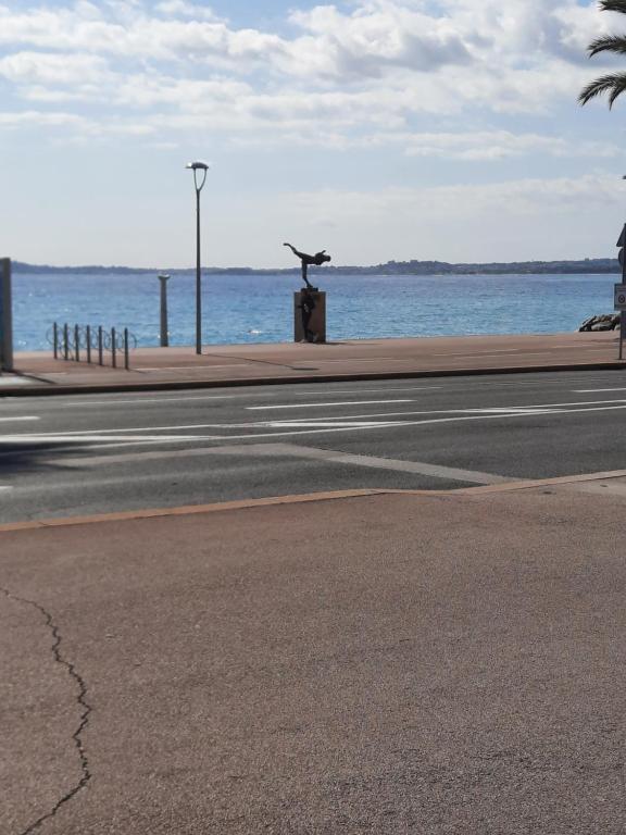 a street with a bird statue next to the ocean at MONA LISA in Cagnes-sur-Mer