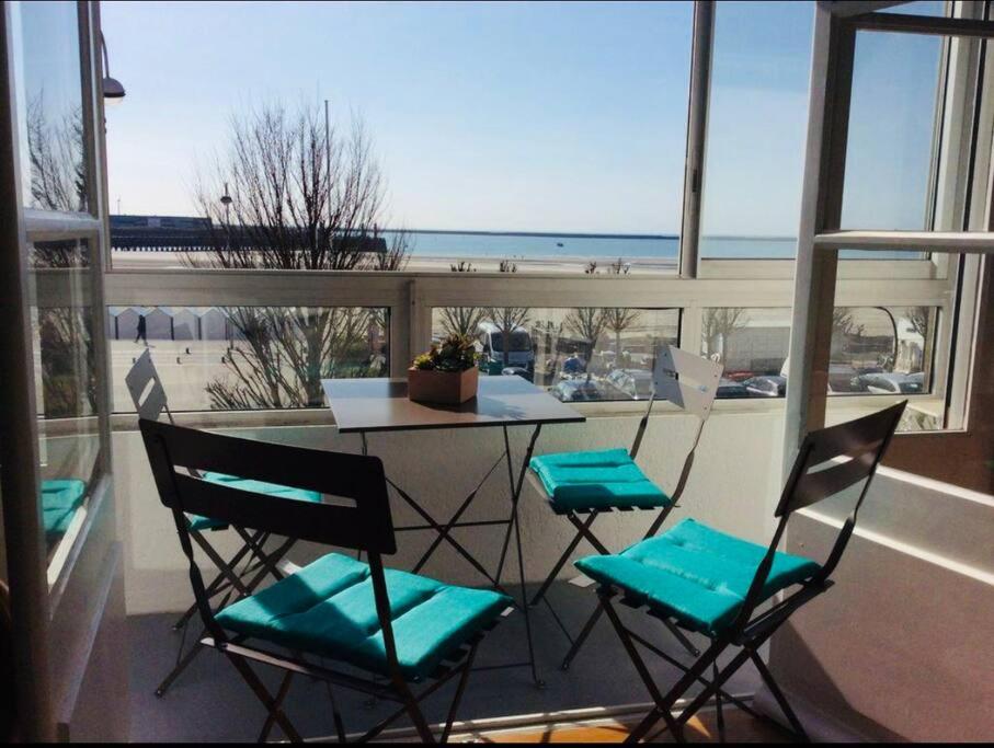 une table et des chaises sur un balcon avec vue sur l'océan dans l'établissement La Belle Vue - Duplex 6 pers, Face Mer & Parking, à Boulogne-sur-Mer