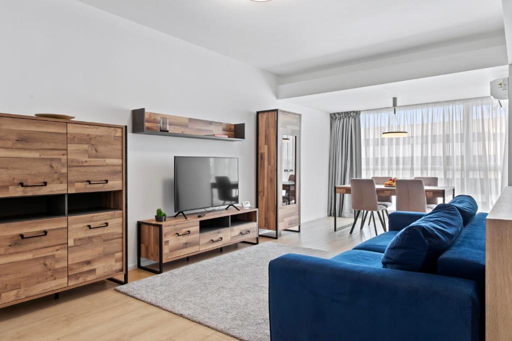 a living room with a blue couch and a television at Atria Urban Gateway, 2BR Condo + Pool in Bucharest