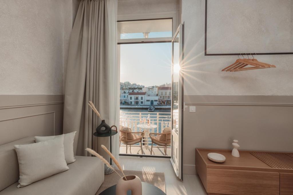 un soggiorno con un divano e una grande finestra di Luxury Suites by Lato ad Ágios Nikólaos