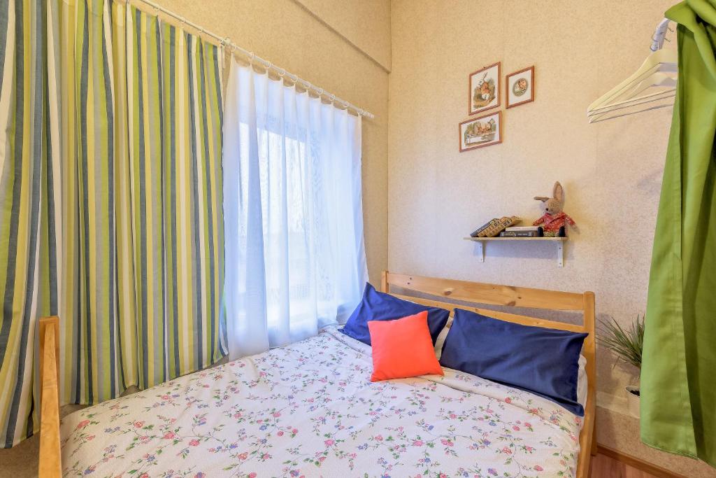 a bedroom with a bed with blue and orange pillows at WonderHostel on Nevsky in Saint Petersburg