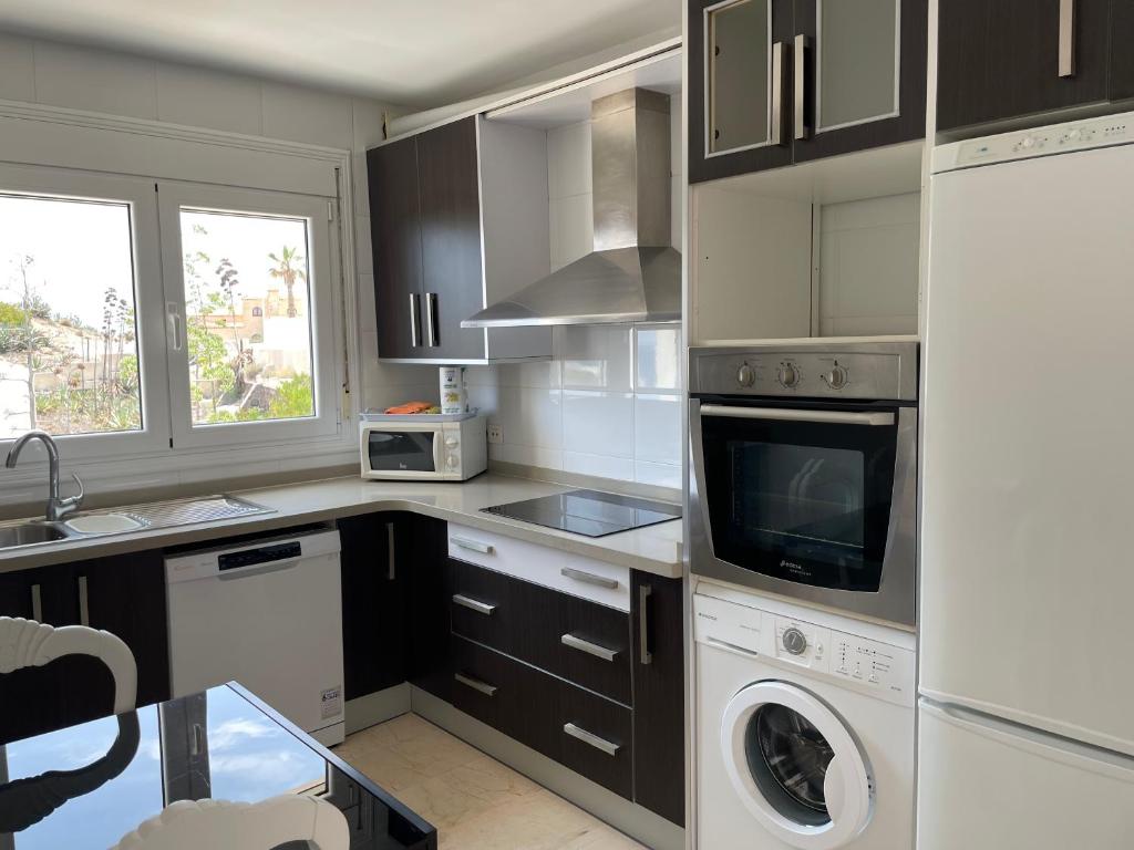 a kitchen with a washer and dryer in it at Apartamentos Dulcemar Frente al Mar con zona SPA in San José