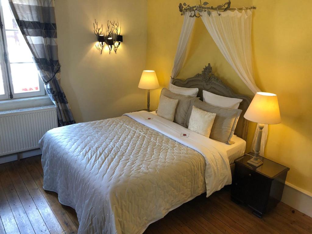 ein Schlafzimmer mit einem großen weißen Bett mit zwei Lampen in der Unterkunft Hotel de Charme 'zum Schiff' in Iffezheim