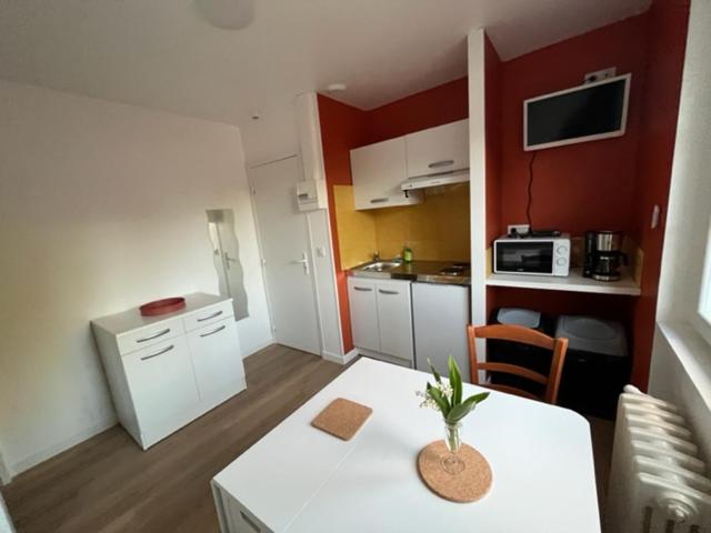 uma pequena cozinha com uma mesa branca num quarto em Les gîtes de Mazélise em Mazerolles