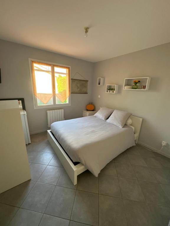 Un dormitorio con una cama grande y una ventana en B&B Chez Jaika Chambre d hotes, en Belleville-en-Beaujolais