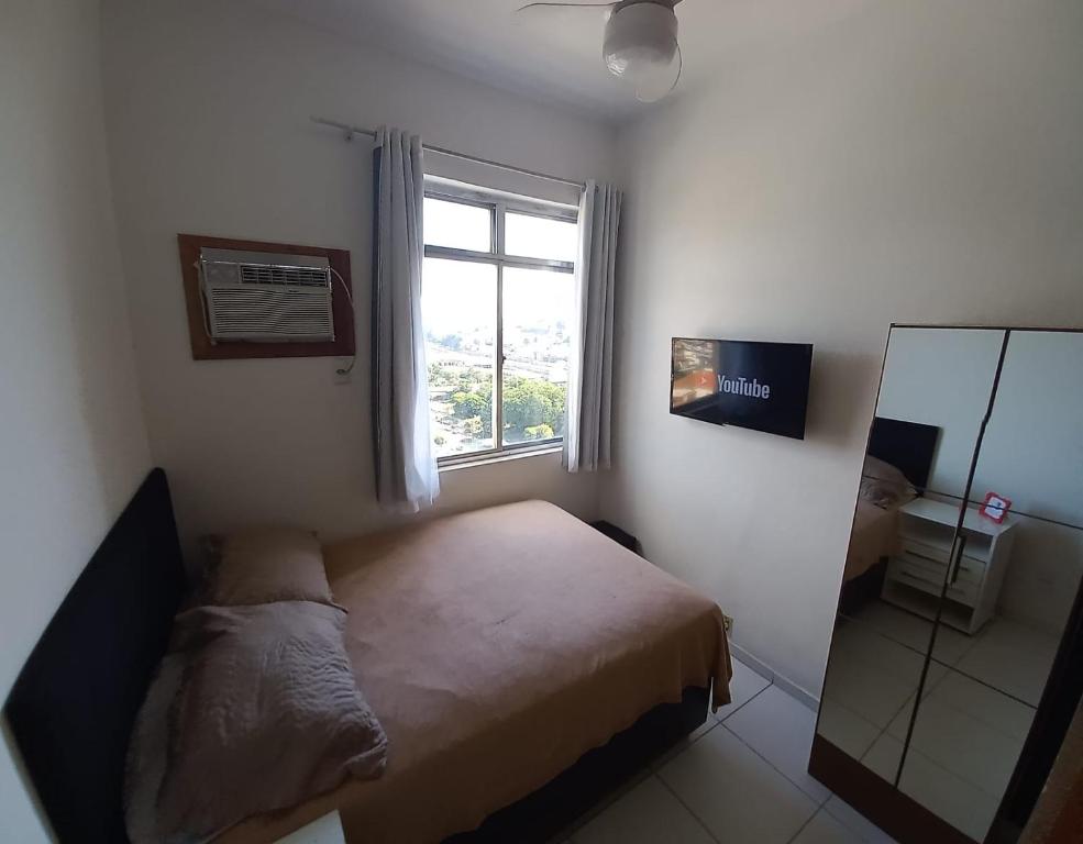 een kleine slaapkamer met een bed en een raam bij Centro, Maracanã, rodoviaria perto, SmarTV, vista fantástica in Rio de Janeiro