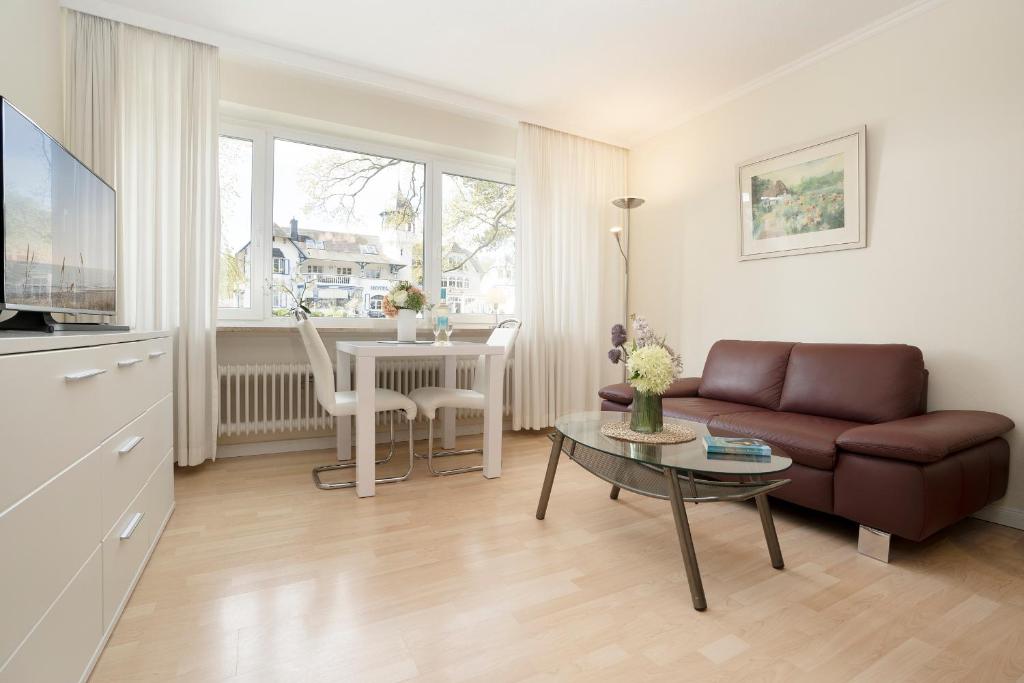 ein Wohnzimmer mit einem Sofa und einem Tisch in der Unterkunft Haus Seepferdchen am Meer Appartement 2 in Timmendorfer Strand