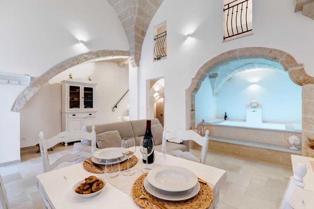 - une salle à manger avec une table, des chaises et une bouteille de vin dans l'établissement Suite L' Alcova, à Fasano