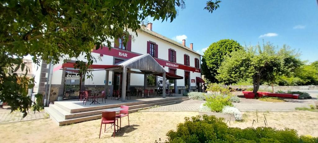 Saint-Rémy-de-Blot的住宿－Logis hôtels Auberge du Château，外面有桌椅的建筑