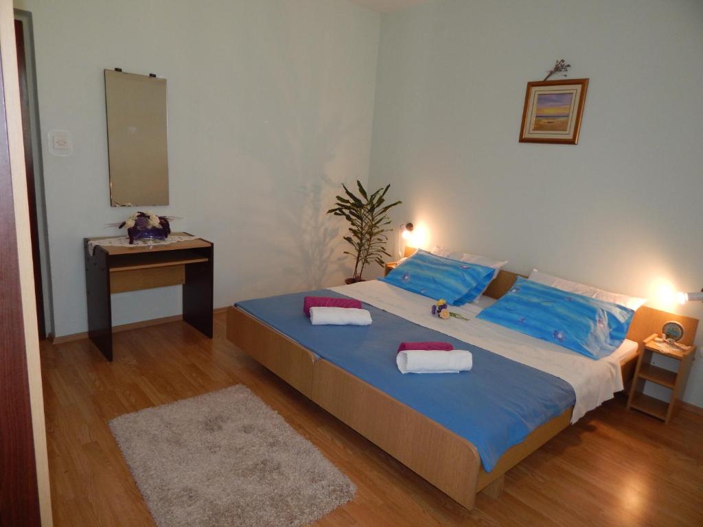 - une chambre dotée d'un lit avec des draps bleus et un miroir dans l'établissement Apartment Štrmac, à Labin