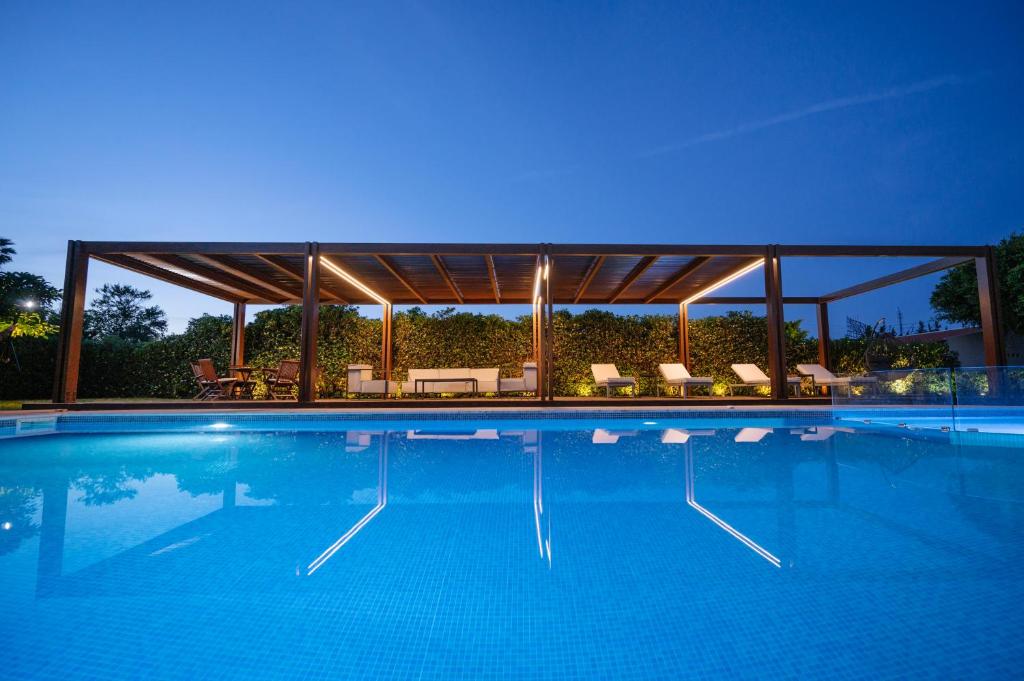 uma grande piscina com um pavilhão com uma piscina em BlueGreen Villa em Karteros