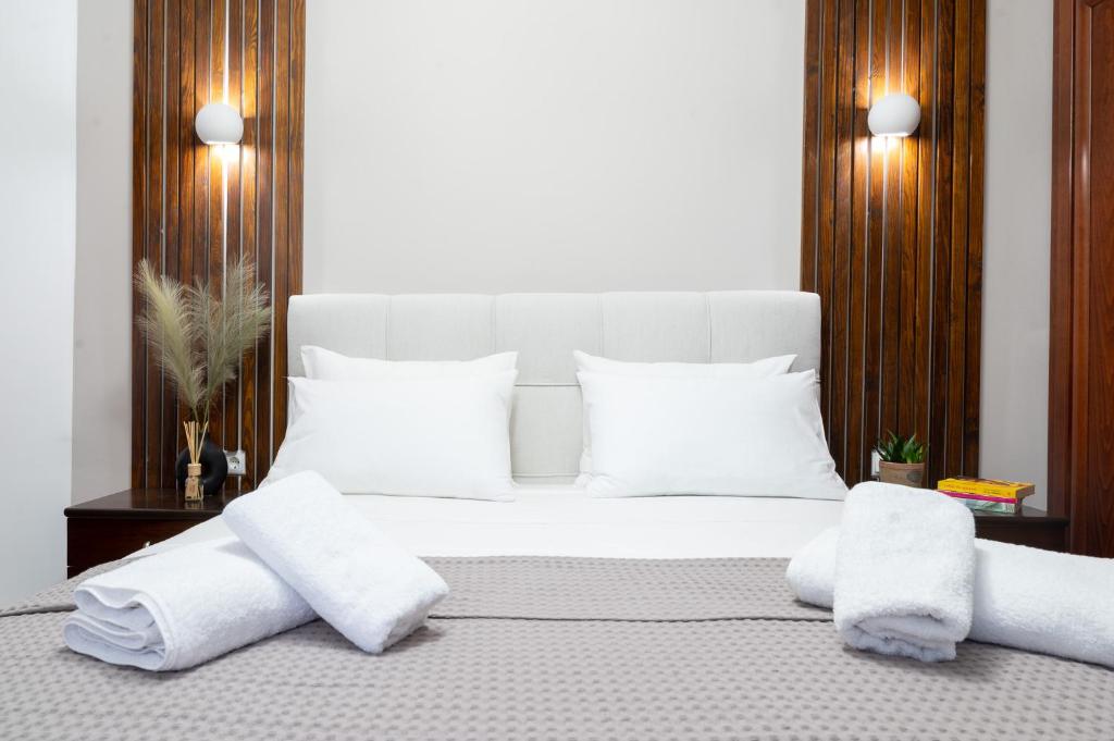 Un dormitorio con una cama blanca con toallas. en Seaside Guesthouse en Kavala