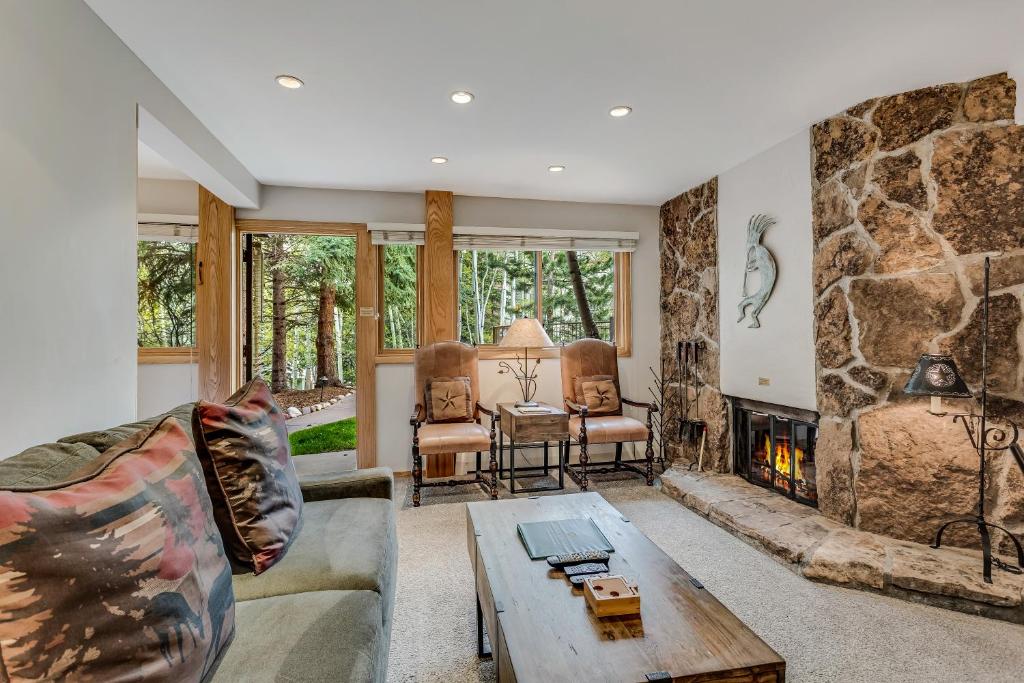 a living room with a large stone fireplace at Laurelwood Condominiums 303 in Snowmass Village