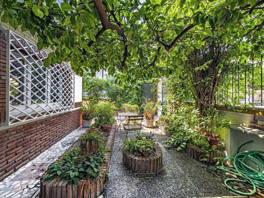 a garden with a table and some plants at Casa Limonero con parking gratis junto a centro histórico in Granada