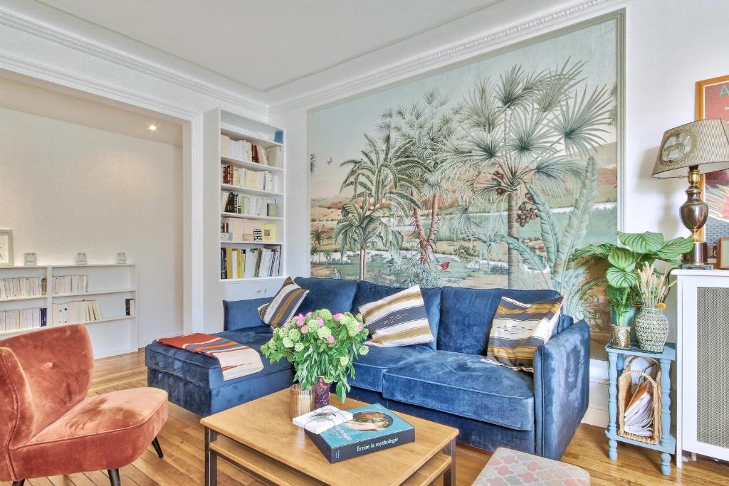 - un canapé bleu dans le salon orné d'une peinture murale dans l'établissement Appartement Chernoviz - Welkeys, à Paris