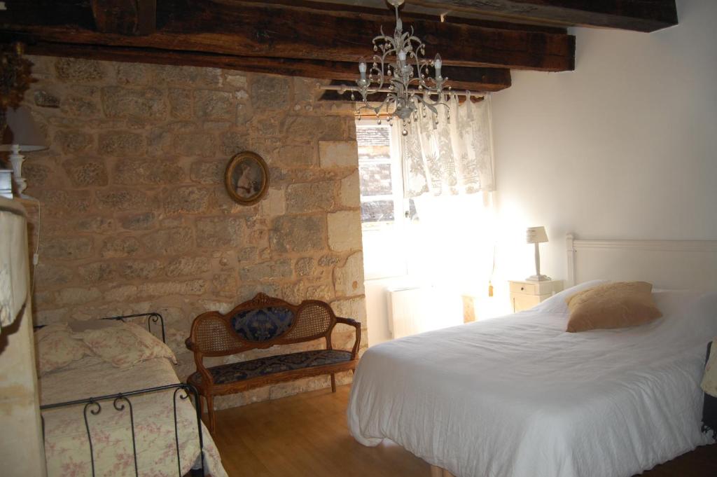 une chambre avec un lit et un mur en pierre dans l'établissement 7 Au Charme d'Antan, à Beaumont-du-Périgord
