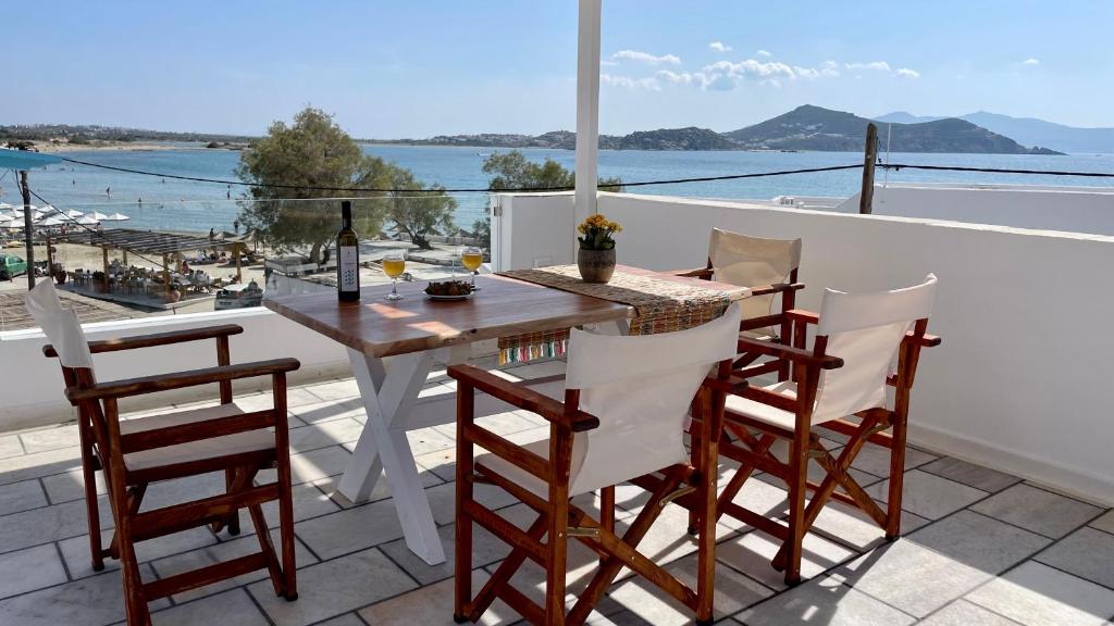 een tafel en stoelen op een balkon met uitzicht op de oceaan bij Summer Times Studios in Naxos Chora