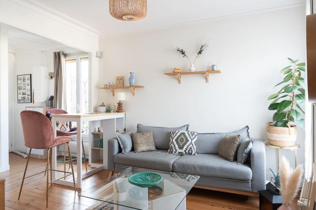 a living room with a couch and a table at Nice cocoon with garden near the Bois de Vincennes in Saint-Maurice