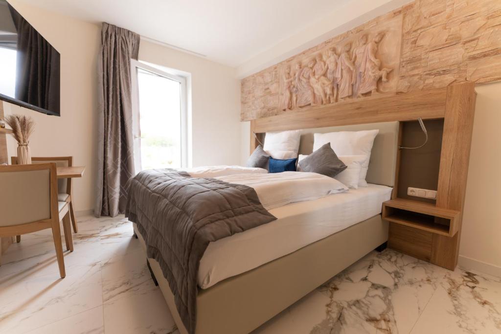 ein Schlafzimmer mit einem großen Bett und einem Fenster in der Unterkunft Hotel & Restaurant Sparta in Oldenburg