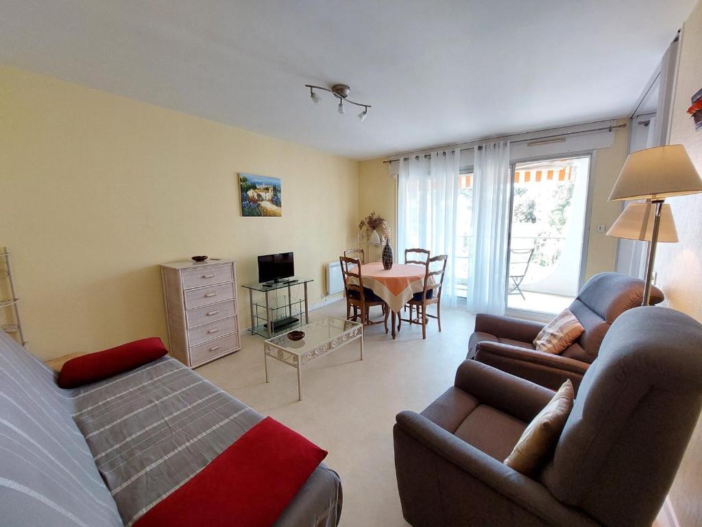 un salon avec un lit, un canapé et une table dans l'établissement Appartement Centre-Ville Saint-Palais, 400m Plage, Balcon, Parking Privé - FR-1-550-58, à Saint-Palais-sur-Mer