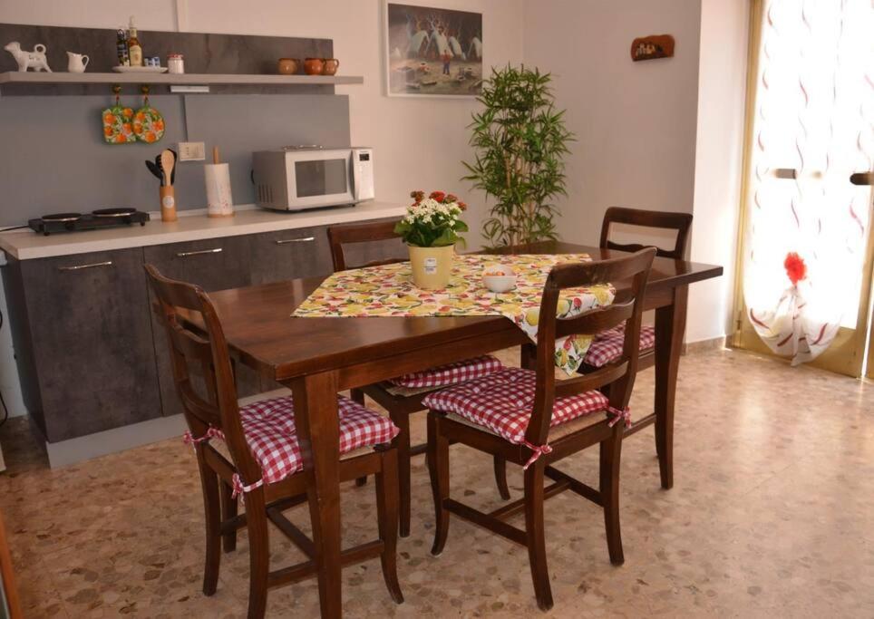 einem Esstisch mit Stühlen und einem Tisch mit Blumen darauf in der Unterkunft Da Giulia in Belluno Veronese
