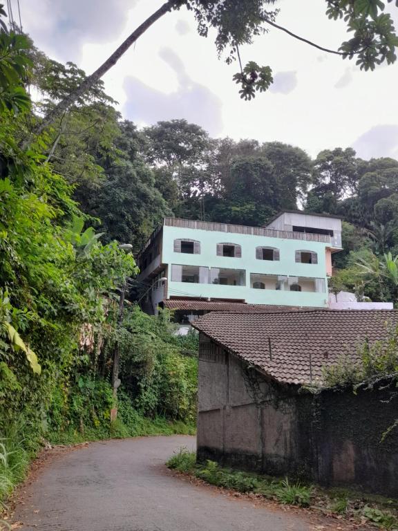 un edificio blanco al lado de una carretera en Eco hostel 013 en São Vicente