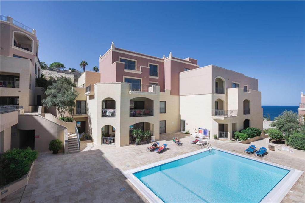 ein Apartment mit einem Pool vor einem Gebäude in der Unterkunft LUX Seaview & Pool-Hosted by Sweetstay in Mellieħa