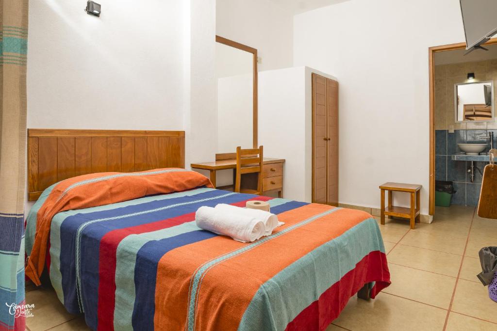 a bedroom with a bed with two towels on it at Hotel VidaMar in Puerto Escondido