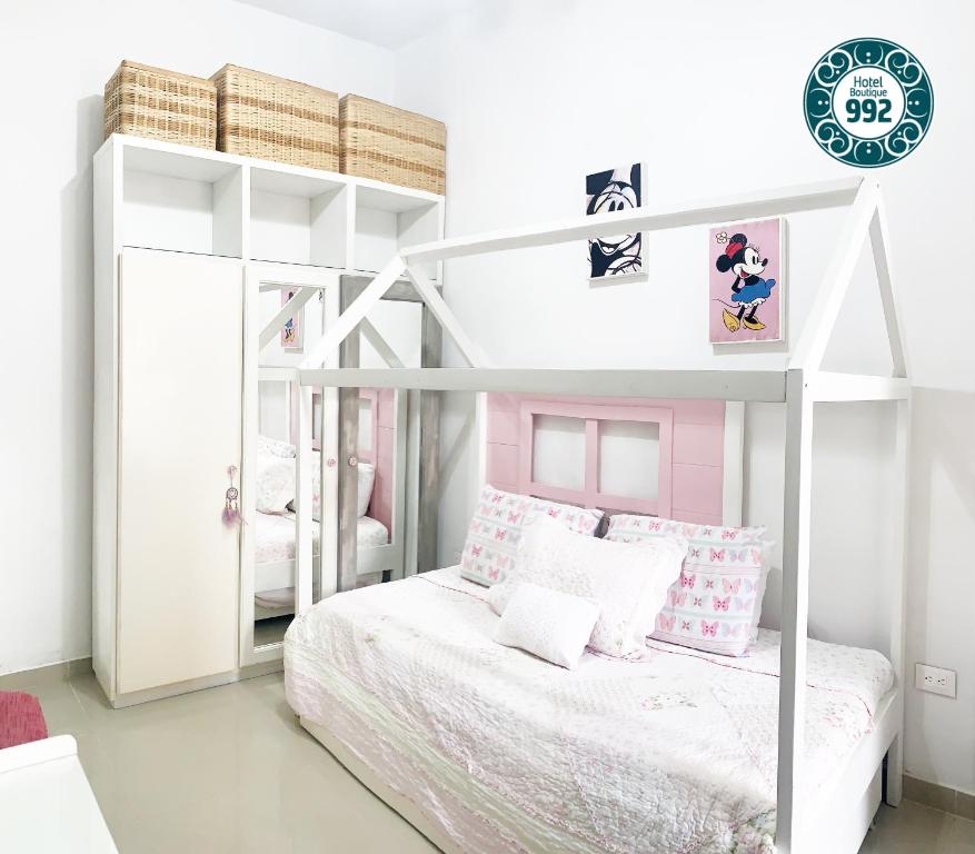 - une chambre avec des lits superposés blancs aux accents roses dans l'établissement Casa 9-92 Hotel Boutique, à Guaduas
