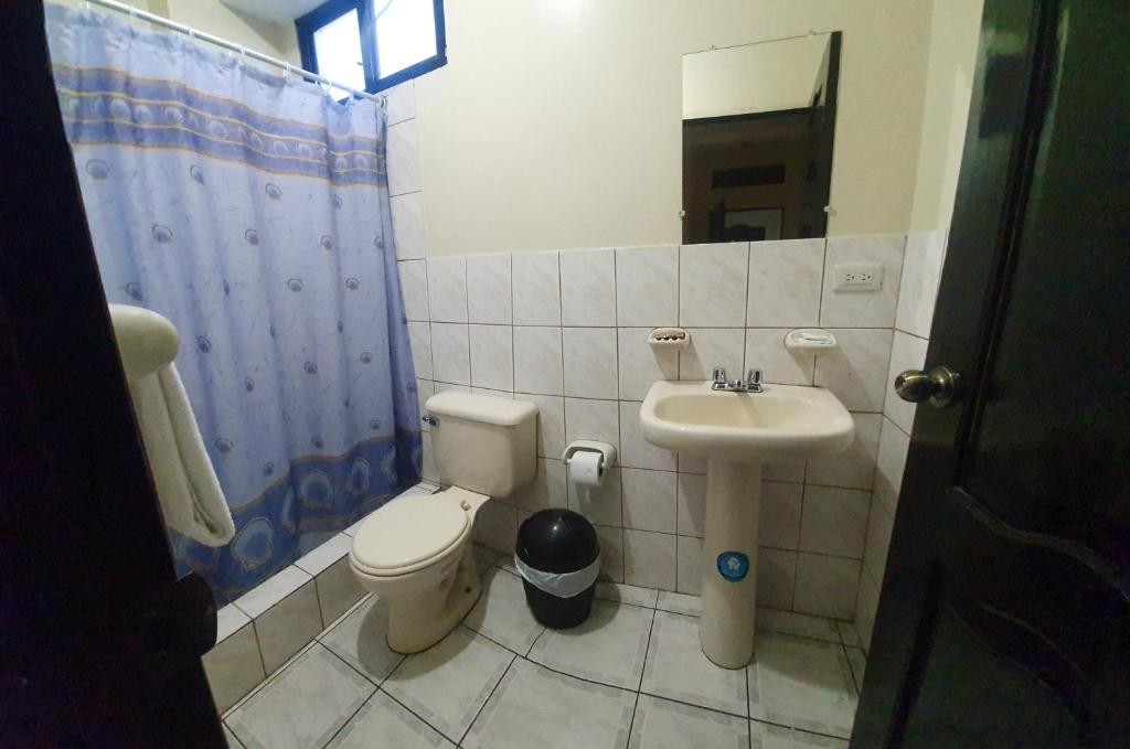 a bathroom with a toilet and a sink at Hotel Cisne II in Santa Elena