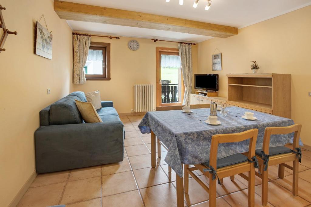 un soggiorno con un tavolo e un divano di Bait dal Cucù App Plascianet a Livigno