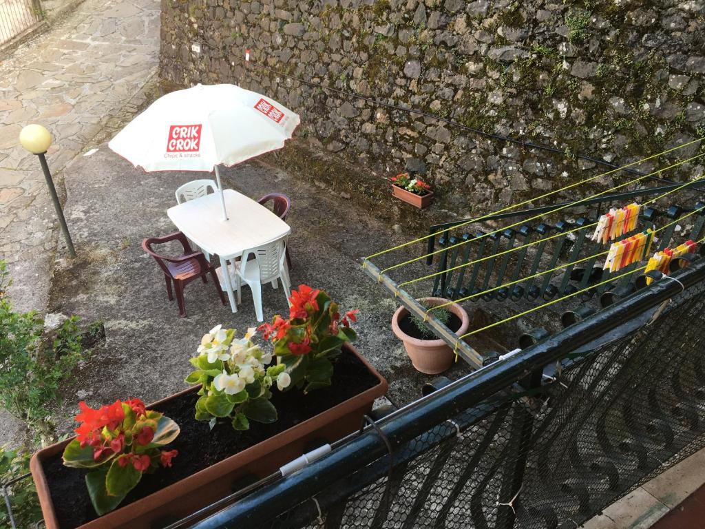 una sombrilla, una mesa, sillas y flores en Ca da Lalla en Carro