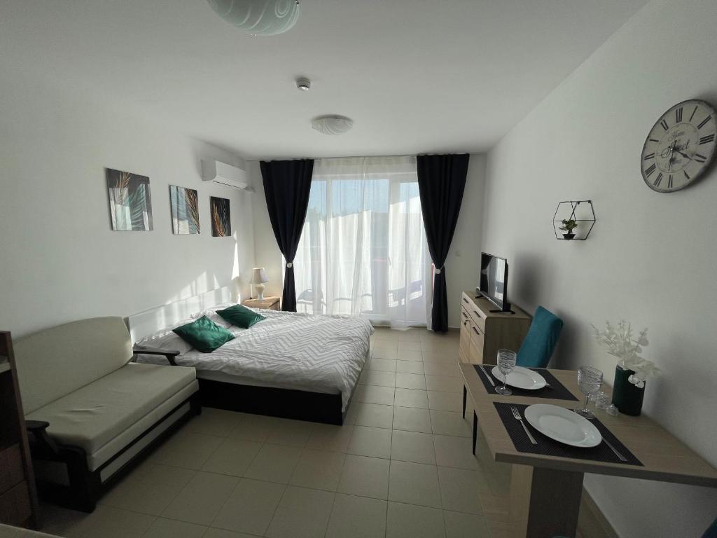 1 dormitorio con cama, sofá y reloj en Admiral Plaza, en Sunny Beach