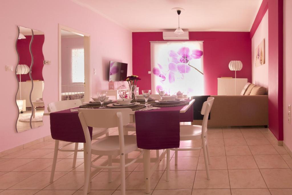 a dining room with purple walls and a table and chairs at Flower Pot Complex Aparts! in Preveza