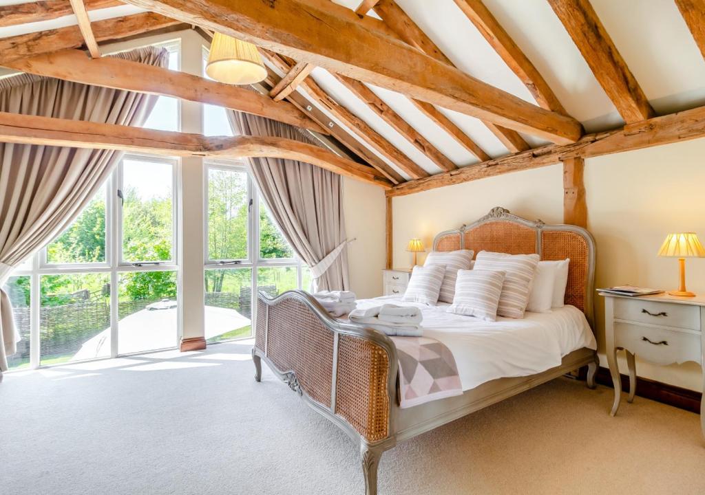 a bedroom with a bed and a large window at Brand Barn Sutton in Sutton