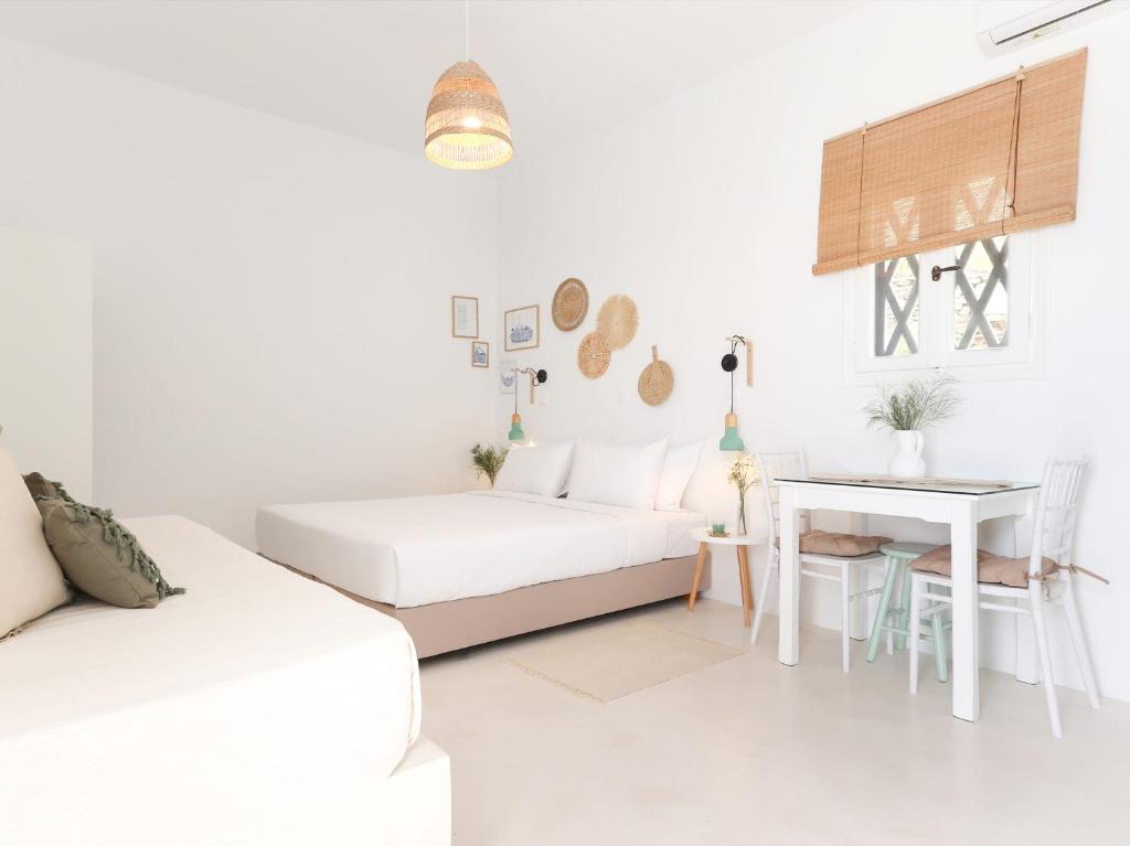 Sala de estar blanca con sofá y mesa en La Vista TINOS, en Agios Ioannis