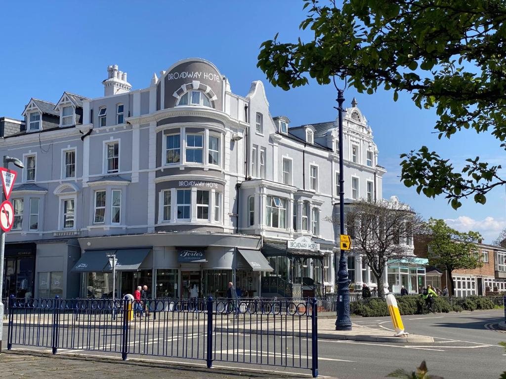 a large white building on the corner of a street at The Broadway Hotel in Llandudno