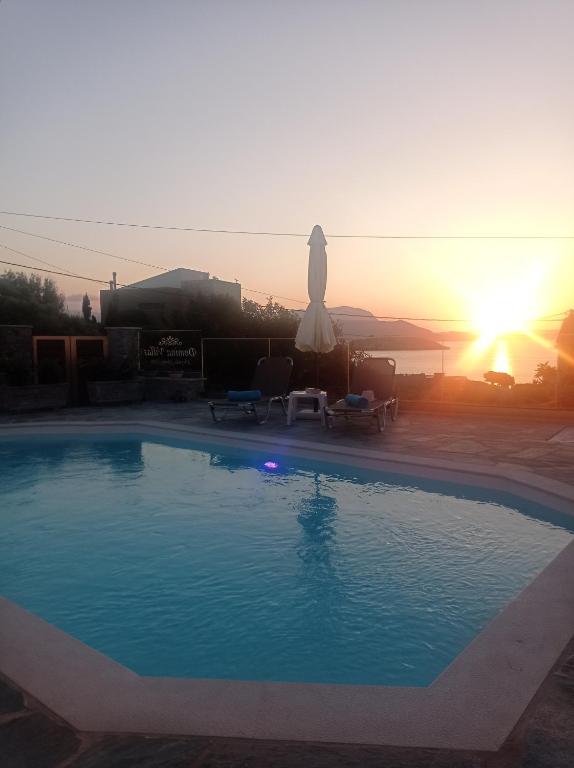 a swimming pool with the sunset in the background at Domina Villas in Almirida