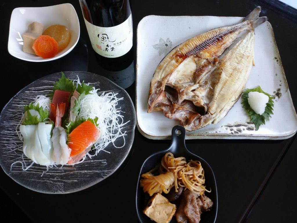 a table topped with plates of food with a fish at Abashirikai no Taiyo - Vacation STAY 14558 in Abashiri