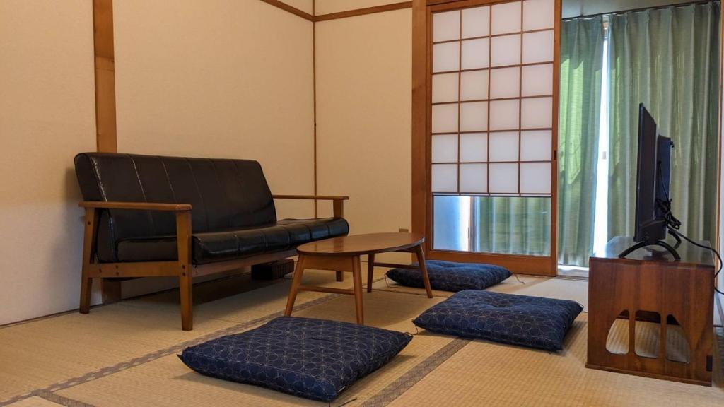 a living room with a chair and a table at Kiyomizu Donguri-an - Vacation STAY 14648 in Kyoto