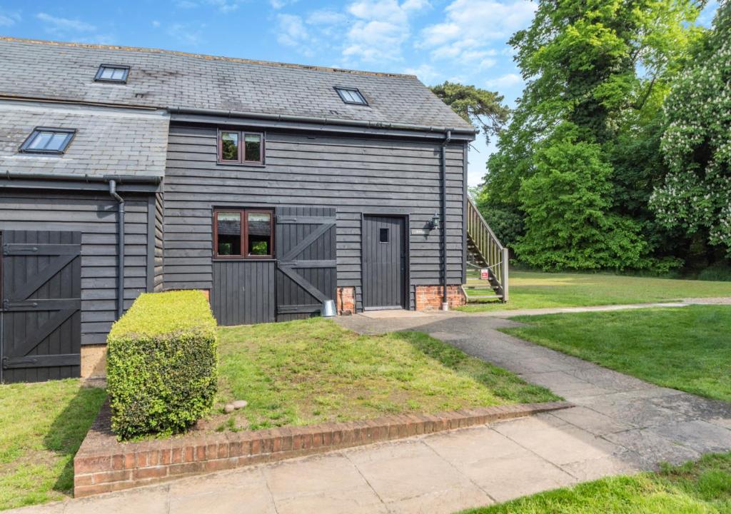 a gray house with a garage and a driveway at Sewell Barn Sutton in Sutton