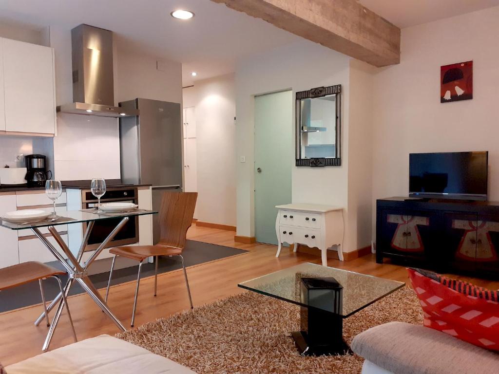 cocina y sala de estar con mesa y sofá en Apartamento Brian, en San Sebastián