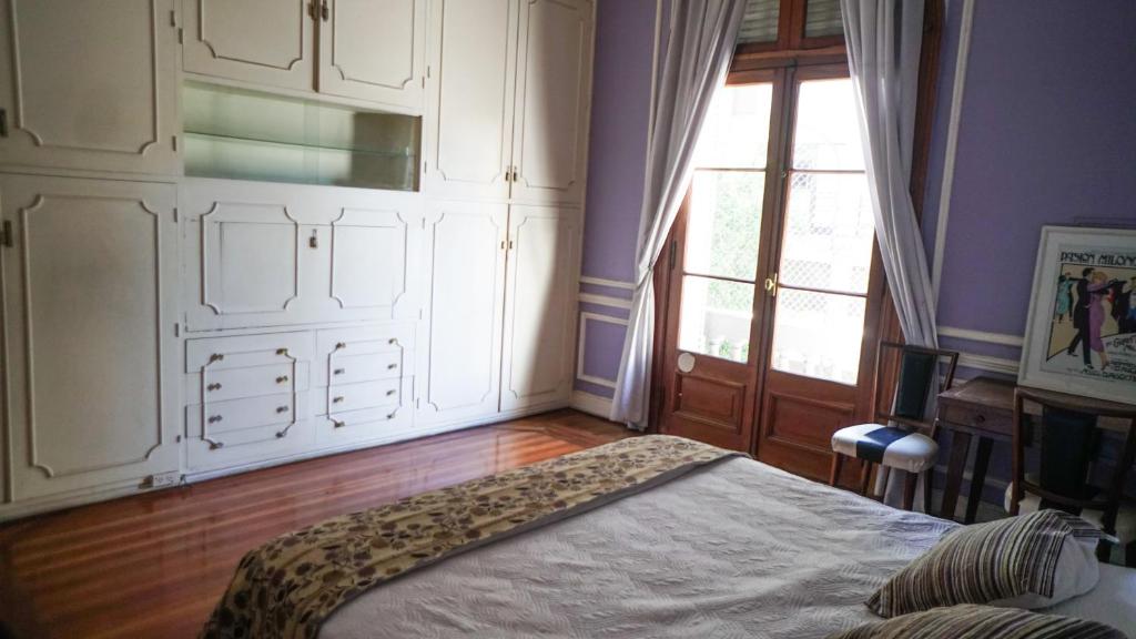 a bedroom with a bed and a large window at Historical Tango House. Priv area 3 BR /7 guests. in Buenos Aires