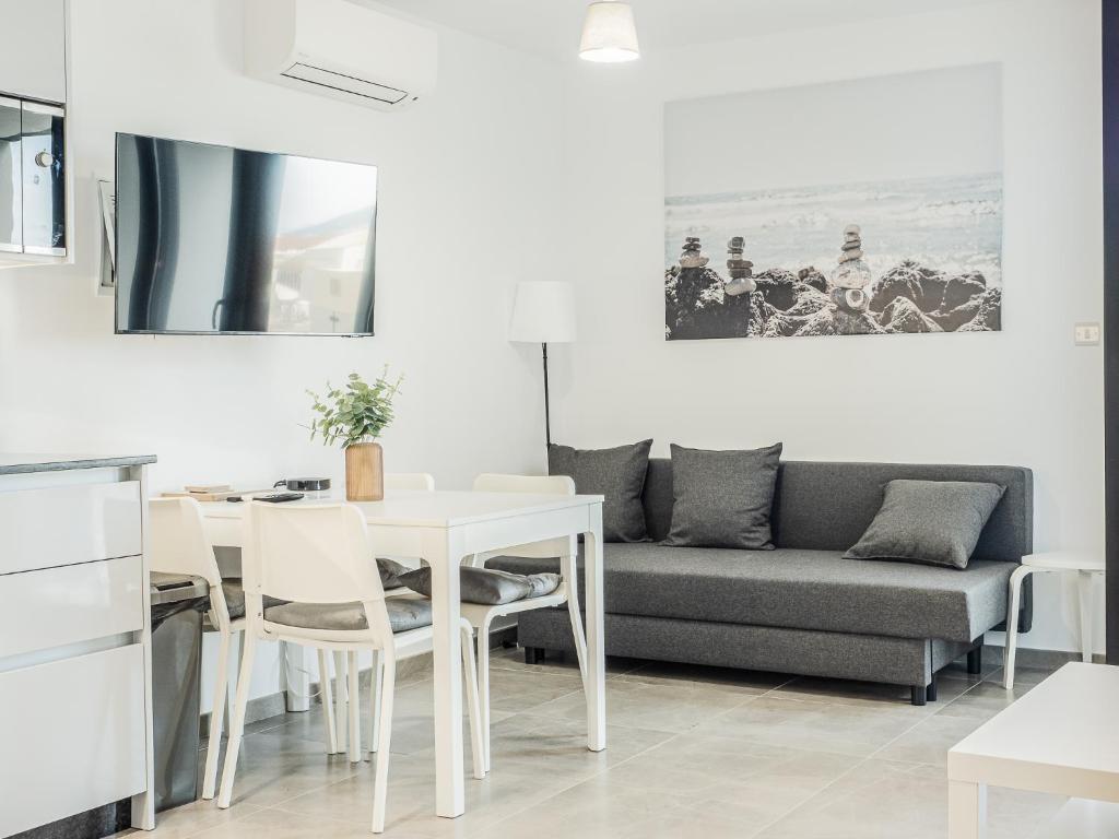 直布羅陀的住宿－Brand New Studio Near The Beach, Gibraltar，客厅配有桌子和沙发