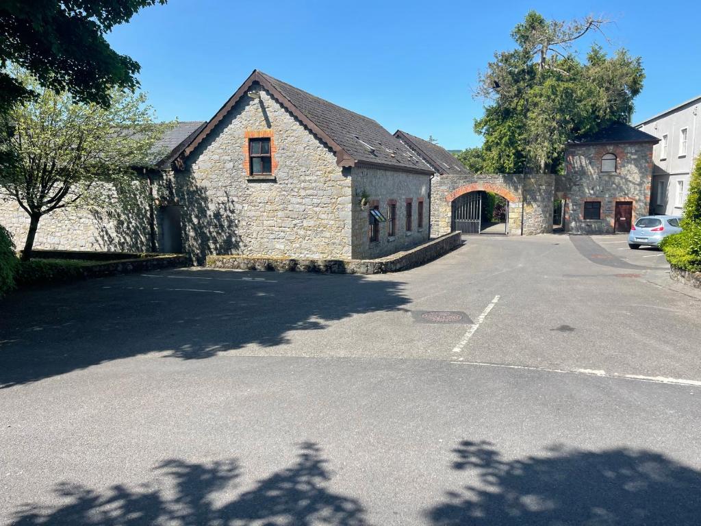 an empty parking lot in front of a stone building at Riverside Lodge in Carlow