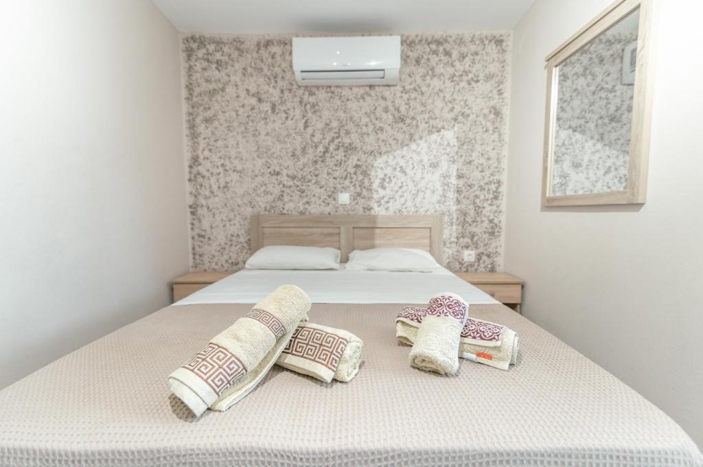 a bedroom with a bed with three pillows on it at Old Town Elpis Suite in Kos Town